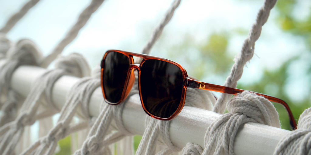 Optic Nerve Wonderspoon sunglasses with a brown frame and brown lenses on a hammock