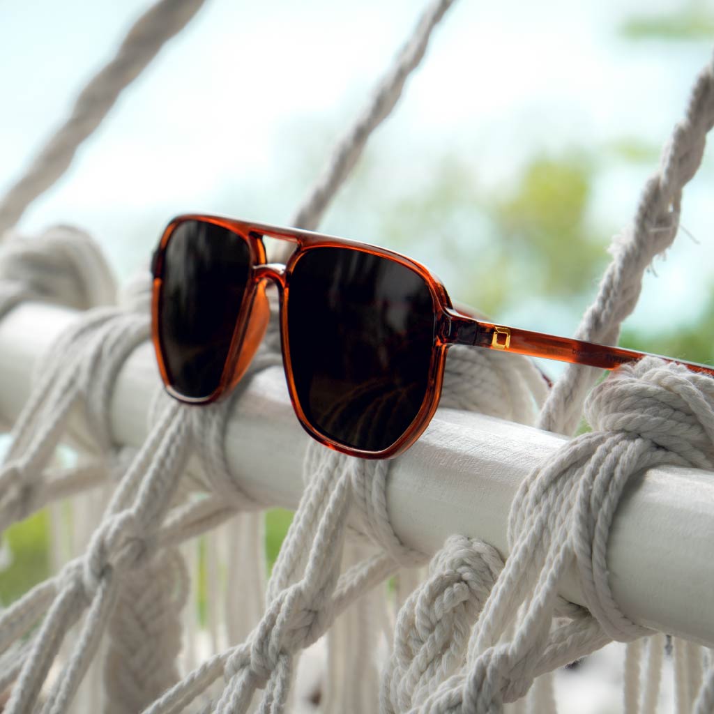 Optic Nerve Wonderspoon sunglasses with a brown frame and brown lenses on a hammock