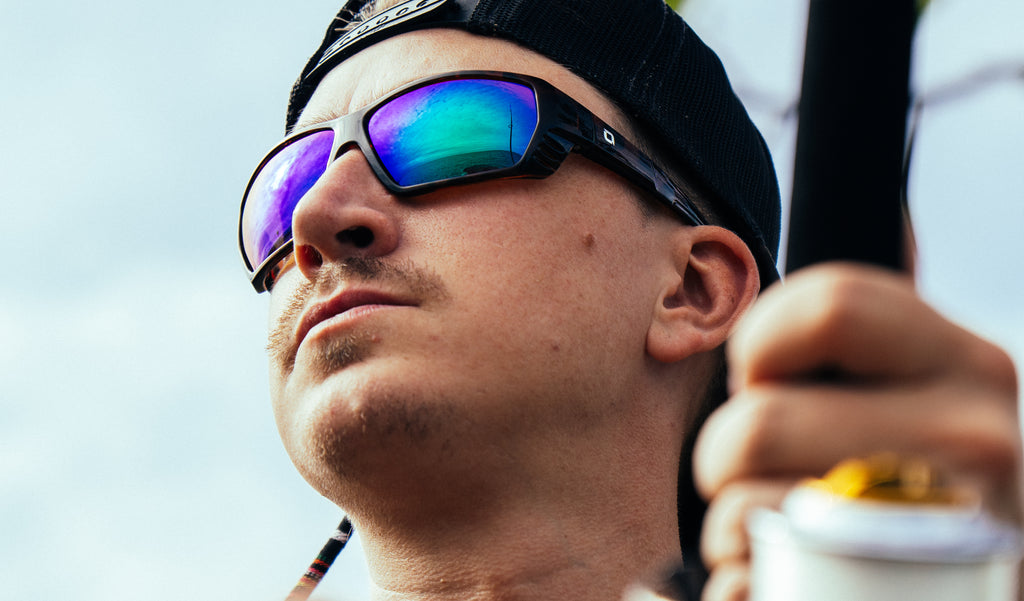 Close up of a fisherman wearing Optic Nerve Yampa sunglasses with a tortoise frame, brown lenses, and a green mirror.