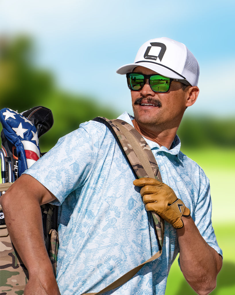 Chris Zaldain wearing an Optic Nerve cap, Zaldaingerous Rumble sunglasses with a tortoise frame, high-def color tuned amber lens, and a green mirror, carrying golf clubs