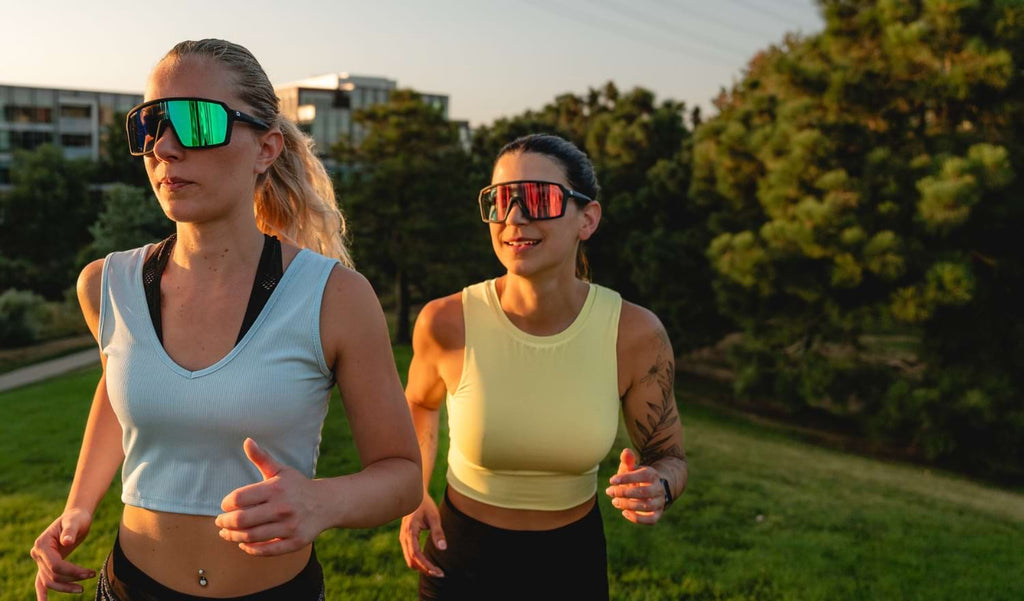 Two woman running wearing Optic Nerve FixiePHENOM sunglasses with a natural background