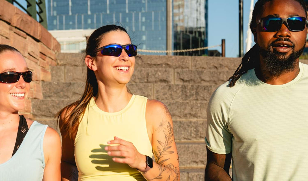Group of people wearing Optic Nerve sunglasses on a sunny day with a blurred city background